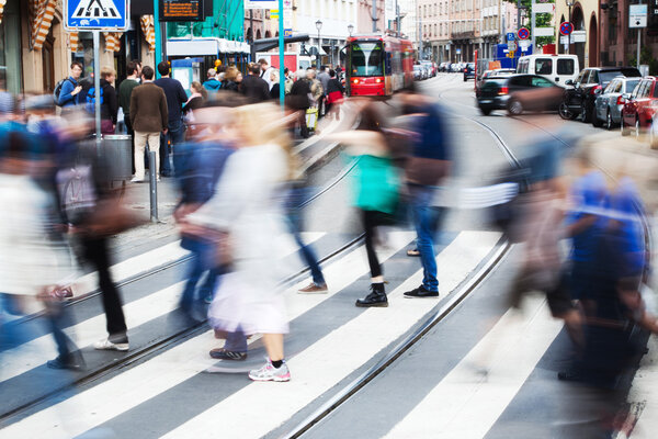 Crowd of people in motion blur crossing a street in Frankfurt, Germany