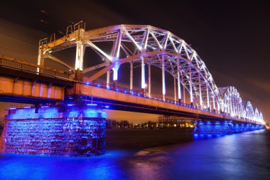 Mavi ışıklı demiryolu köprüsü üzerinde nehir Daugava Riga, Letonya