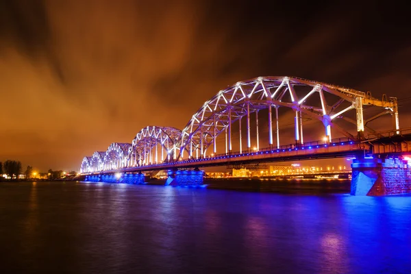 Μπλε φωτιζόμενο σιδηροδρομικής γέφυρας στον ποταμό Daugava στη Ρίγα της Λετονίας — Φωτογραφία Αρχείου