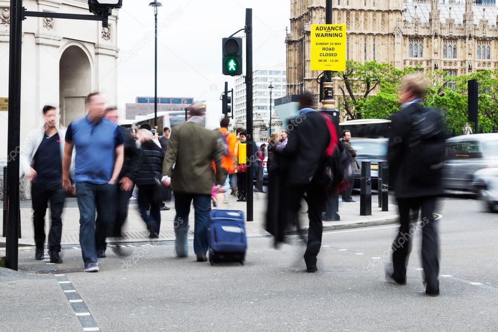 People in motion blur crossing the street in Westminster, London, near Big Ben
