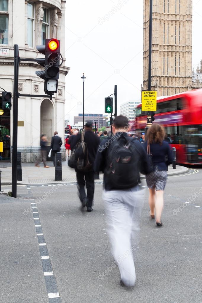 People in motion blur crossing the street in Westminster, London, near Big Ben