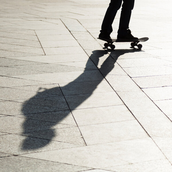 Shadow of a man with a skateboard in the city