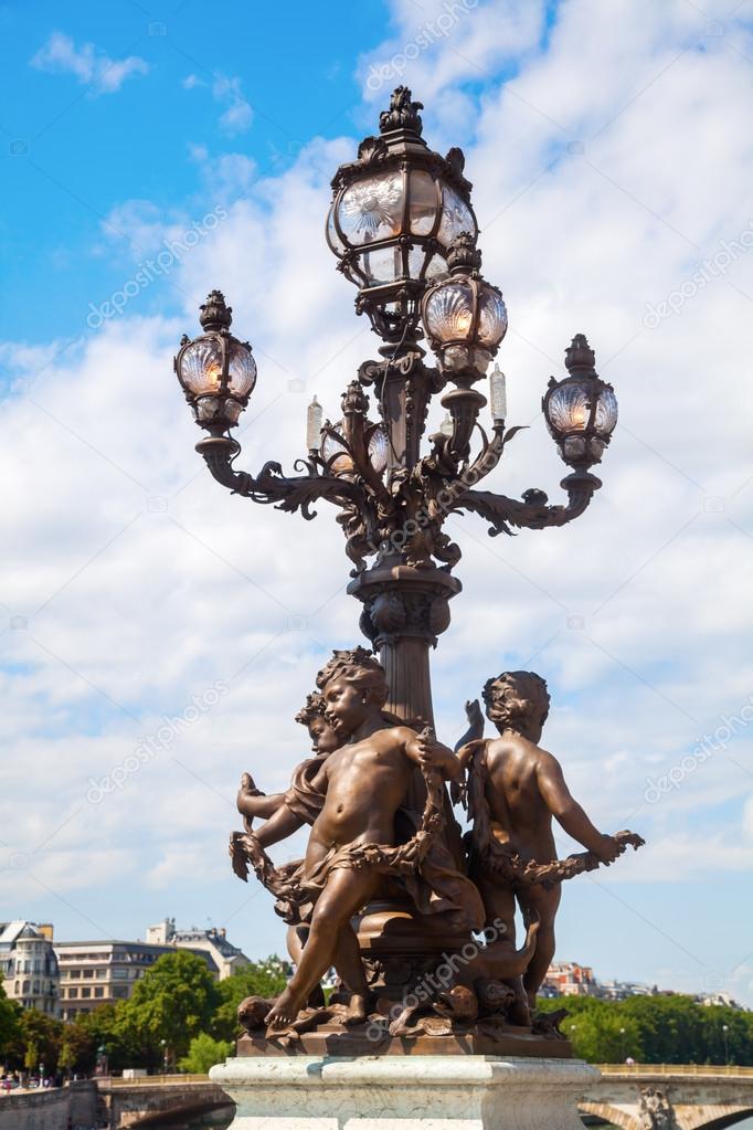 Old street lamp with sculptures on the famous Pont Alexandre III in Paris, France
