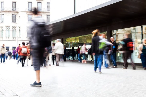 La gente en movimiento se desdibuja en movimiento en una calle comercial — Foto de Stock