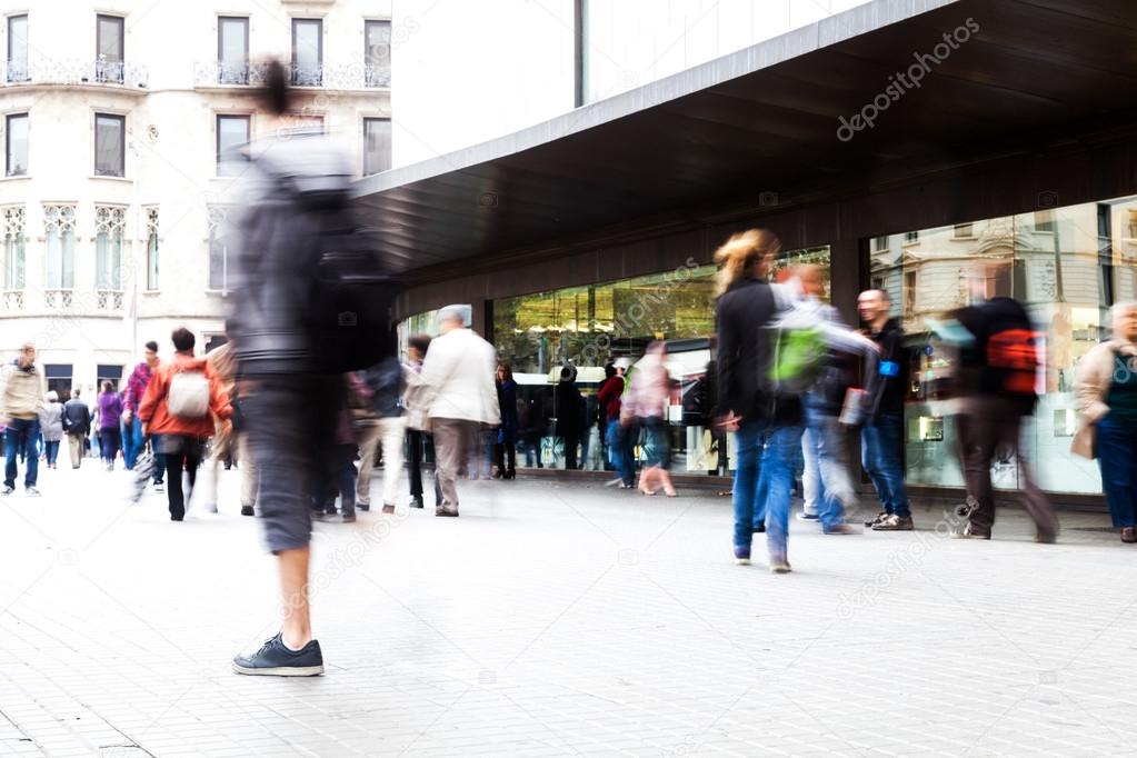 People in motion blur on the move in a shopping street