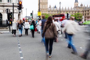 Londra'da Westminster Sarayı yakınındaki bir caddeden karşıya insanlar Hareket Bulanıklığı