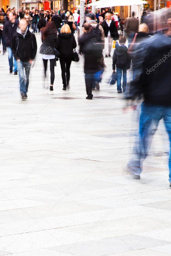 Crowd of people in motion blur on the move in the city