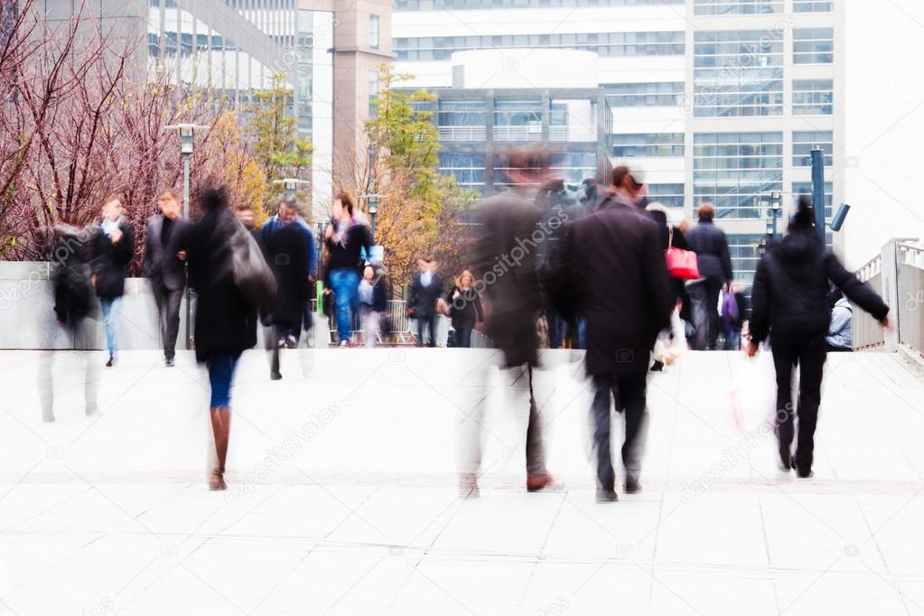 People in motion blur walking in an office park