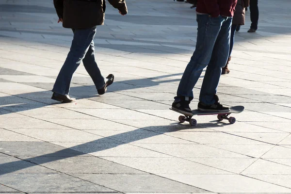 Yaya ve şehrin hamlesinde patenci — Stok fotoğraf