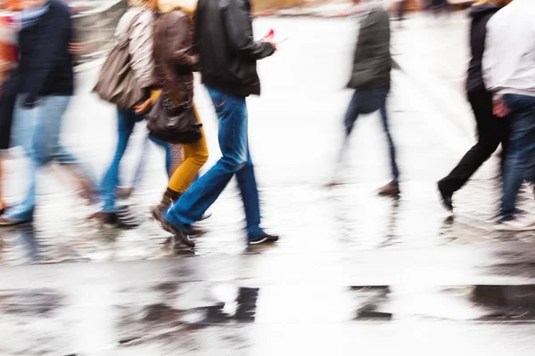Люди, переходящие мокрую улицу в движении размыты — стоковое фото