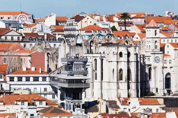 Tetti di Lisbona, Portogallo, con un vecchio rudere della chiesa, l'ascensore Santa Justa e persone non identificate — Foto Stock