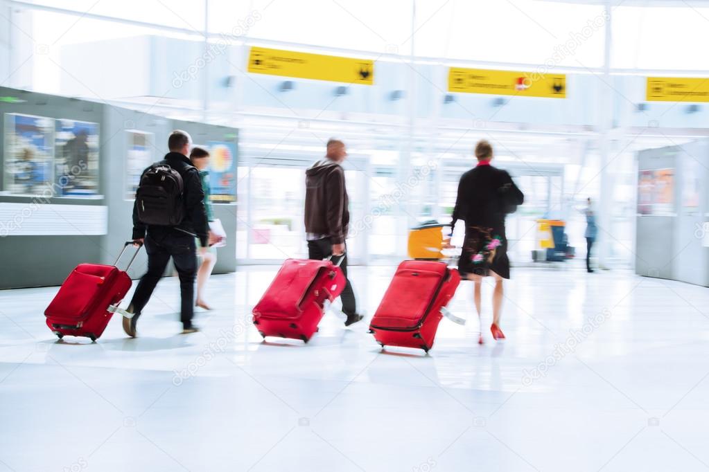 Traveling people with trolleys in motion blur at the airport