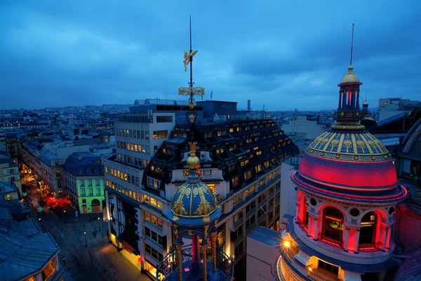 Vista sul tetto di Parigi di notte con edifici storici illuminati Immagine Stock