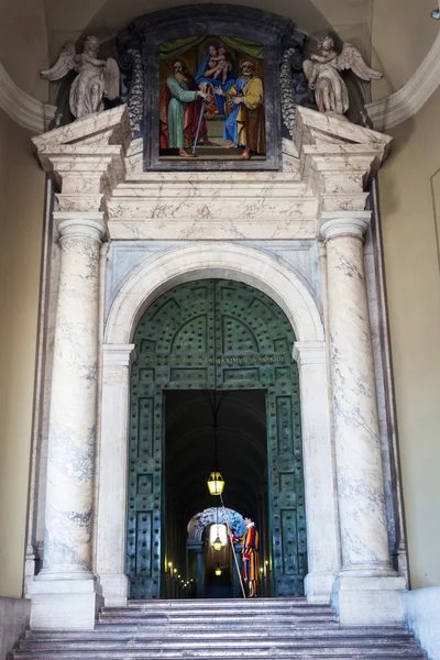 ブロンズのドアのバチカン使徒宮殿でバチカンの教皇スイスガードの正体不明の男. — ストック写真