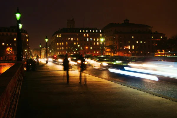 Nacht verkeer op een brug van de Seine bij nacht in Parijs, Frankrijk — Stockfoto