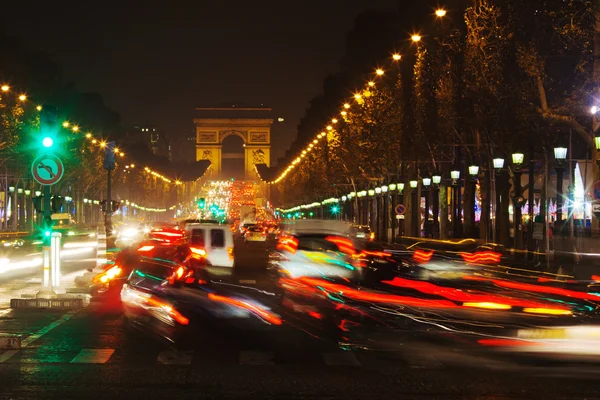 パリ、フランスでバック グラウンドで凱旋門とシャンゼリゼ通りに夜のトラフィック — ストック写真