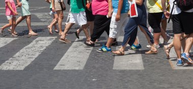 Crowd of people crossing the street at the pedestrian crossing clipart