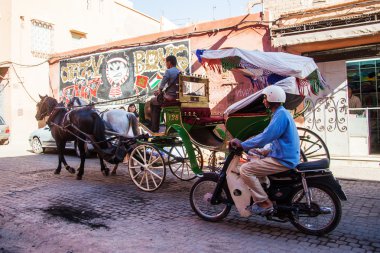 Marakeş, Fas, tipik sokak sahne bir motosiklet binici ve at arabası binici