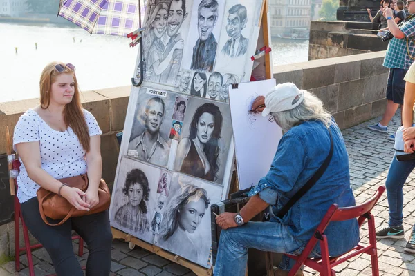 Pouliční umělec a žena na slavného Karlova mostu v Praze, Česko — Stock fotografie