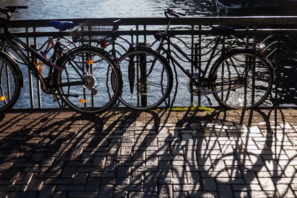 Zaparkowane rowery na Reling ca typowy kanał most w Amsterdam, Holandia — Zdjęcie stockowe