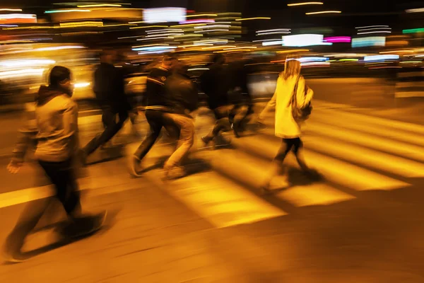 Foule de personnes traversant une rue la nuit — Photo