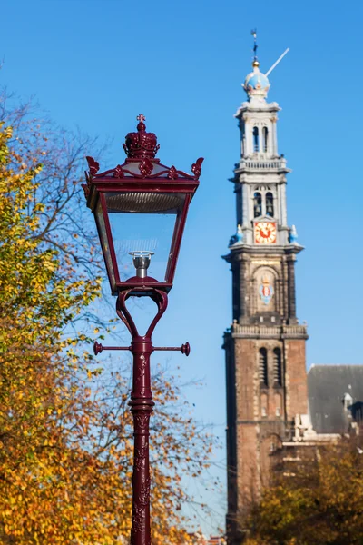 Iglesia borrosa campanario de la Westerkerk en Amsterdam, Países Bajos, detrás de una vieja linterna de la calle —  Fotos de Stock