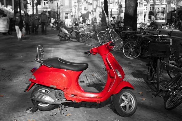 Scooter vermelho com um ambiente preto e branco — Fotografia de Stock