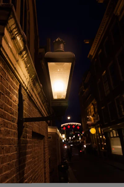 Темная ночь с уличным освещением в старом городе Амстердама, Нидерланды — стоковое фото