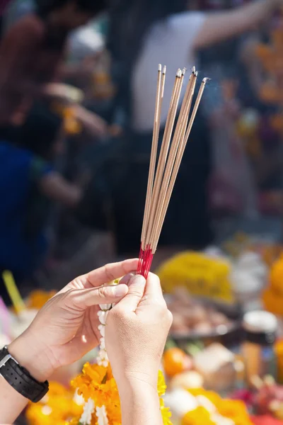 Hands of a person holding incense sticks at the Erawan Shrine in Bangkok, Thailand — Stock Photo, Image