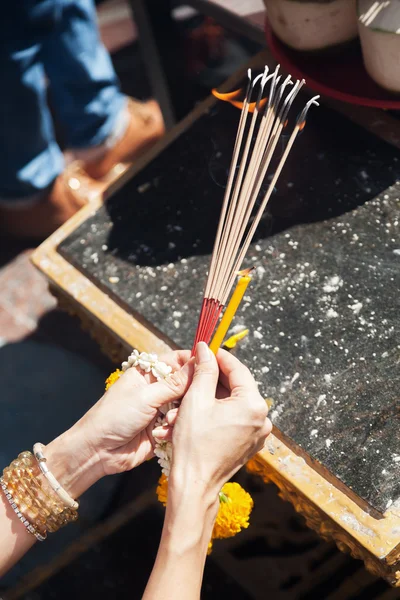 Hands of a person holding incense sticks at the Erawan Shrine in Bangkok, Thailand — Stock Photo, Image