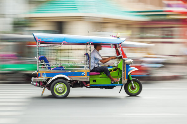 Traditional tuk tuk in Bangkok, Thailand, in motion blur
