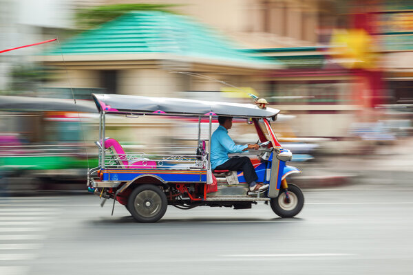 Traditional tuk tuk in Bangkok, Thailand, in motion blur