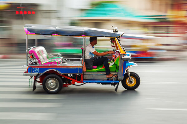 Traditional tuk tuk in Bangkok, Thailand, in motion blur