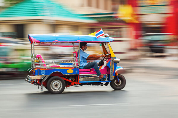 Traditional tuk tuk in Bangkok, Thailand, in motion blur
