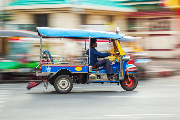 Traditional tuk tuk in Bangkok, Thailand, in motion blur