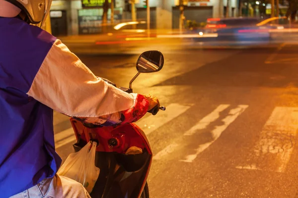 Moped rider in the night traffic