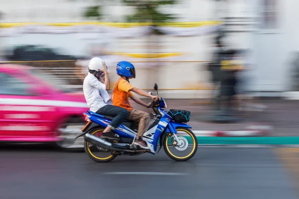 Motocykl s dvěma osobami v pohybu rozostření — Stock fotografie