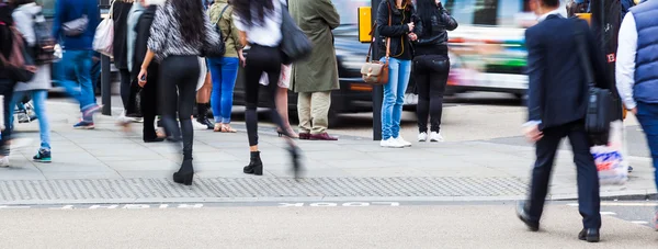 Folle di persone in movimento che attraversano una strada della città — Foto Stock