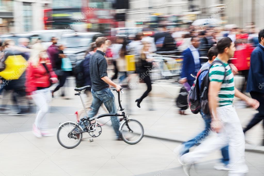 Crowd of people in motion blur crossing a city street