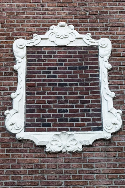 Stucco frame on a brick wall — Stock Photo, Image