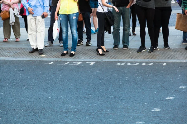 Multitud de personas esperando en la acera para cruzar la calle — Foto de Stock