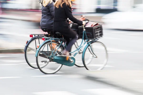 两名妇女用自行车在城市在运动模糊 — 图库照片