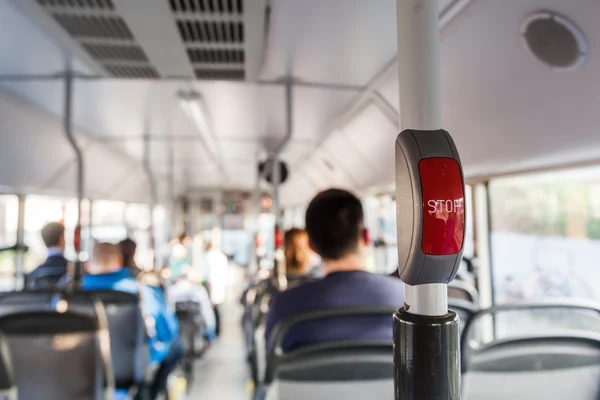 Кнопка Зупинити в автобусі з розмитими людьми на задньому плані — стокове фото