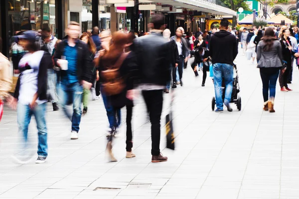 Menigte van mensen aan een winkelstraat in motion blur — Stockfoto