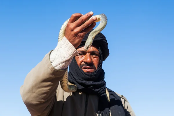 Tuareg man met tulband bedrijf slang in de hand — Stockfoto