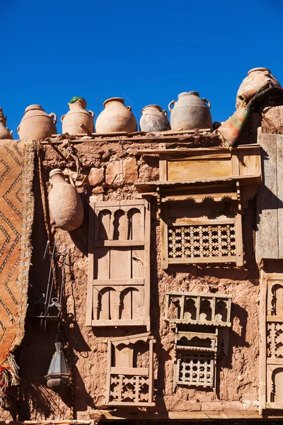 Mud walled house in Morocco with antiquities hanging at the wall — Stock Photo, Image