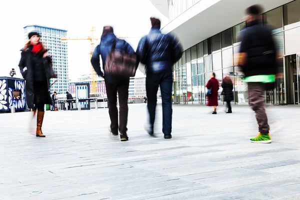 Los viajeros en movimiento se desdibujan en una ciudad moderna — Foto de Stock