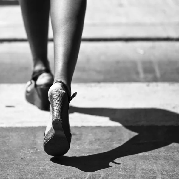 Detalle de imagen en blanco y negro de una mujer negra caminando en el cruce de cebra — Foto de Stock
