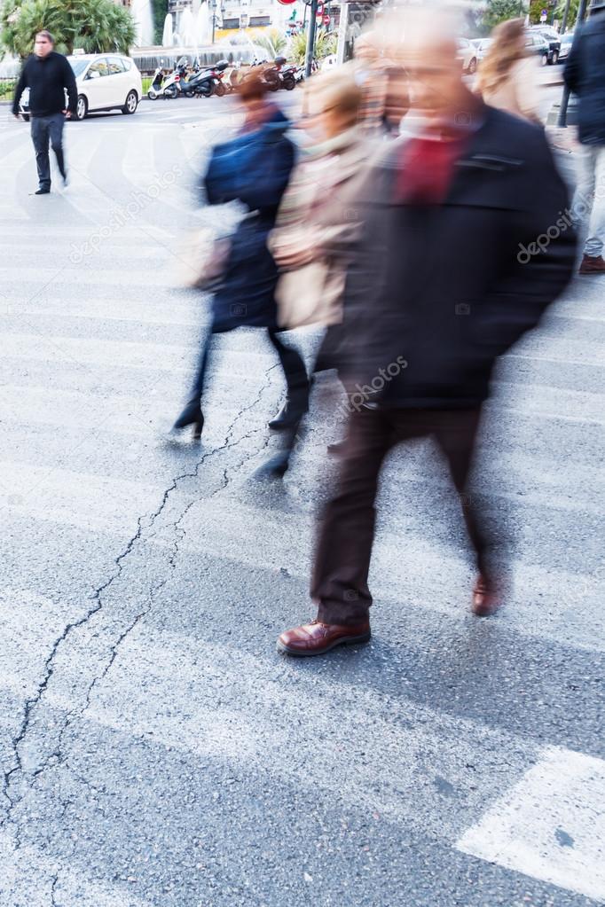 People in motion blur crossing the street