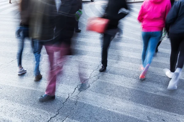 Mensen in motion blur op de voetgangersoversteekplaats — Stockfoto